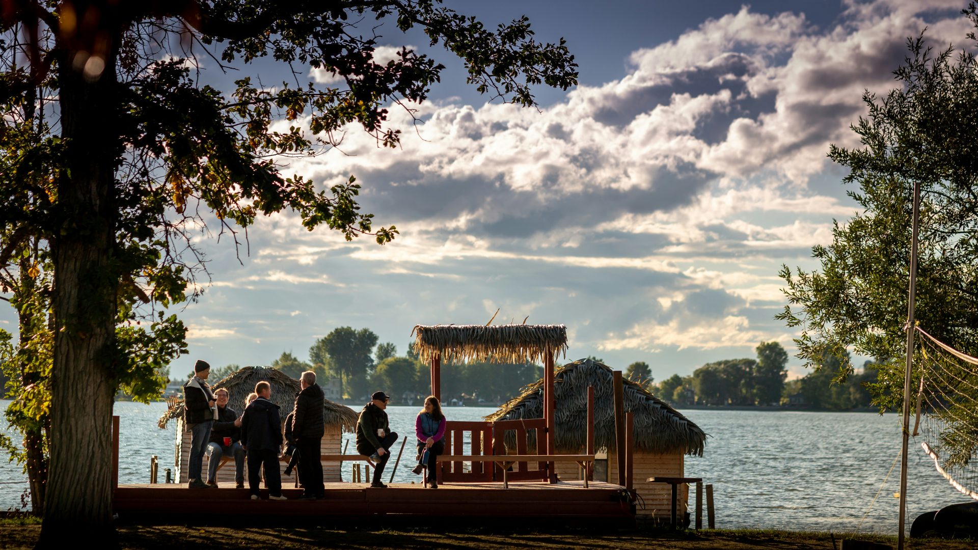 people standing on veranda near body of water